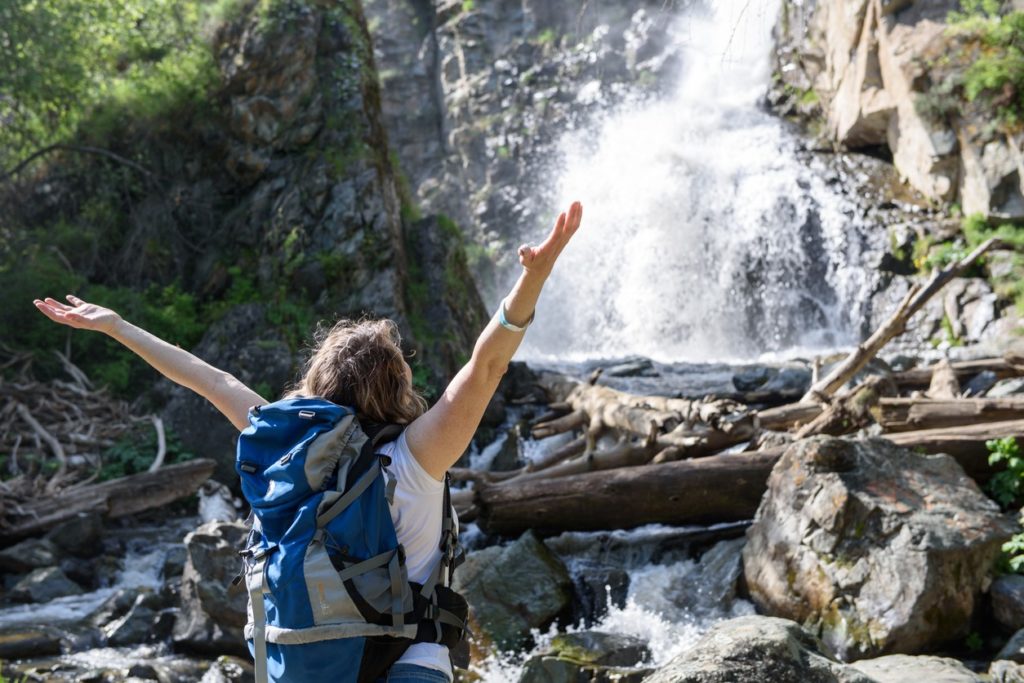 hiker-rejoicing-at-waterfalls