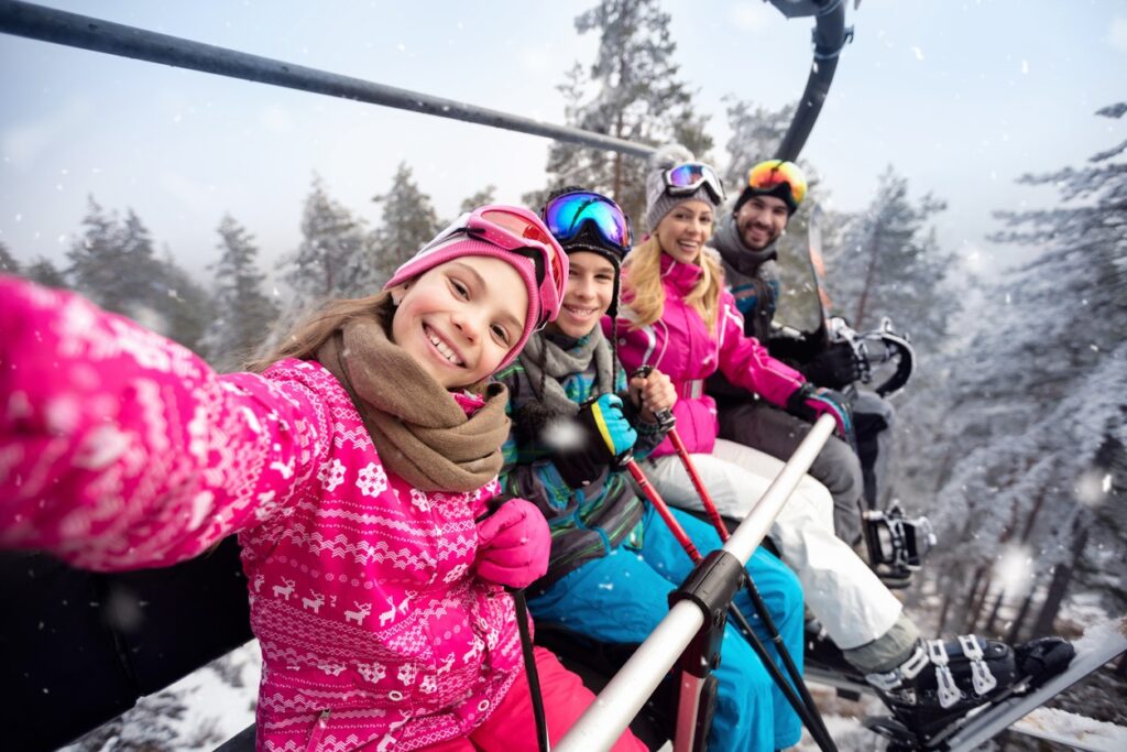 A family of four takes a selfie while riding the chairlift at Mt. Bachelor in Bend, Oregon.