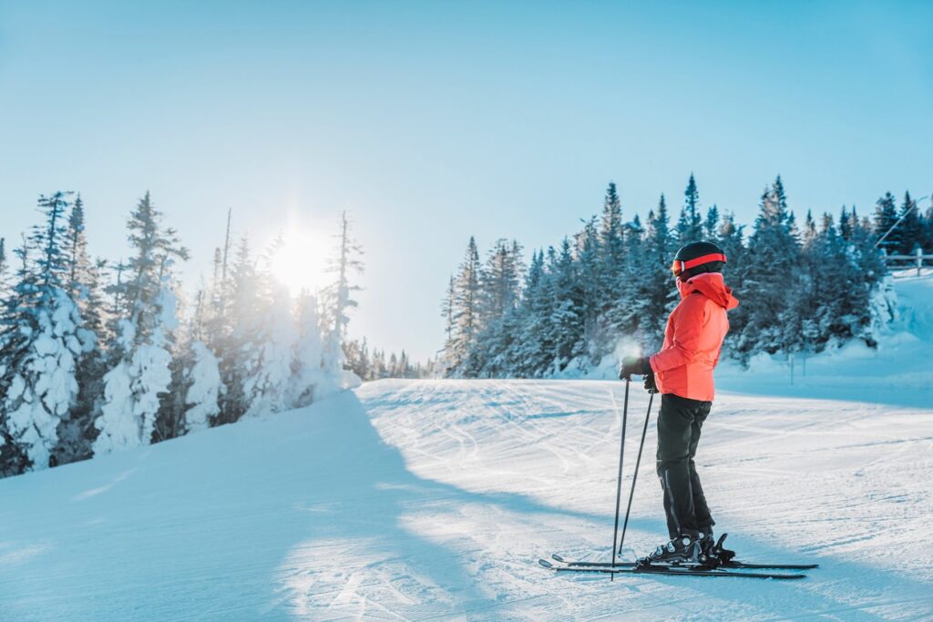 A lone skier stands on a ski trail at Mt. Bachelor in Bend, Oregon, admiring the view. 