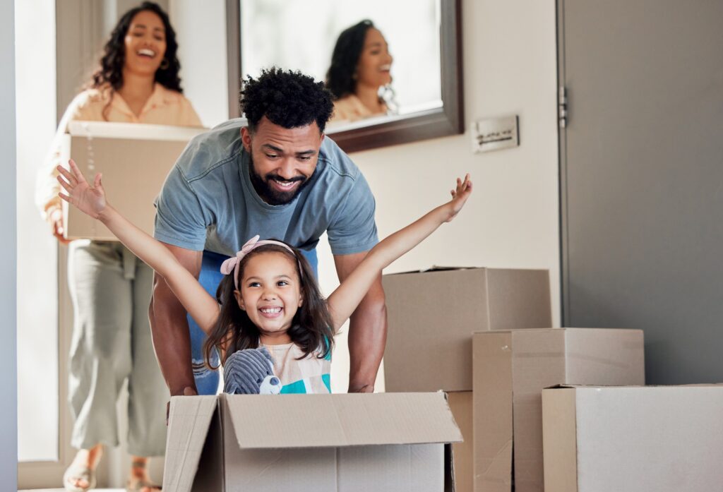 A man pushes his daughter in a box for fun as a family moves into their new home in Bend, Oregon.