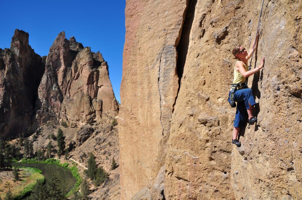 A female climber scales a rock wall in Smith Rock State Park, Bend, Oregon. 