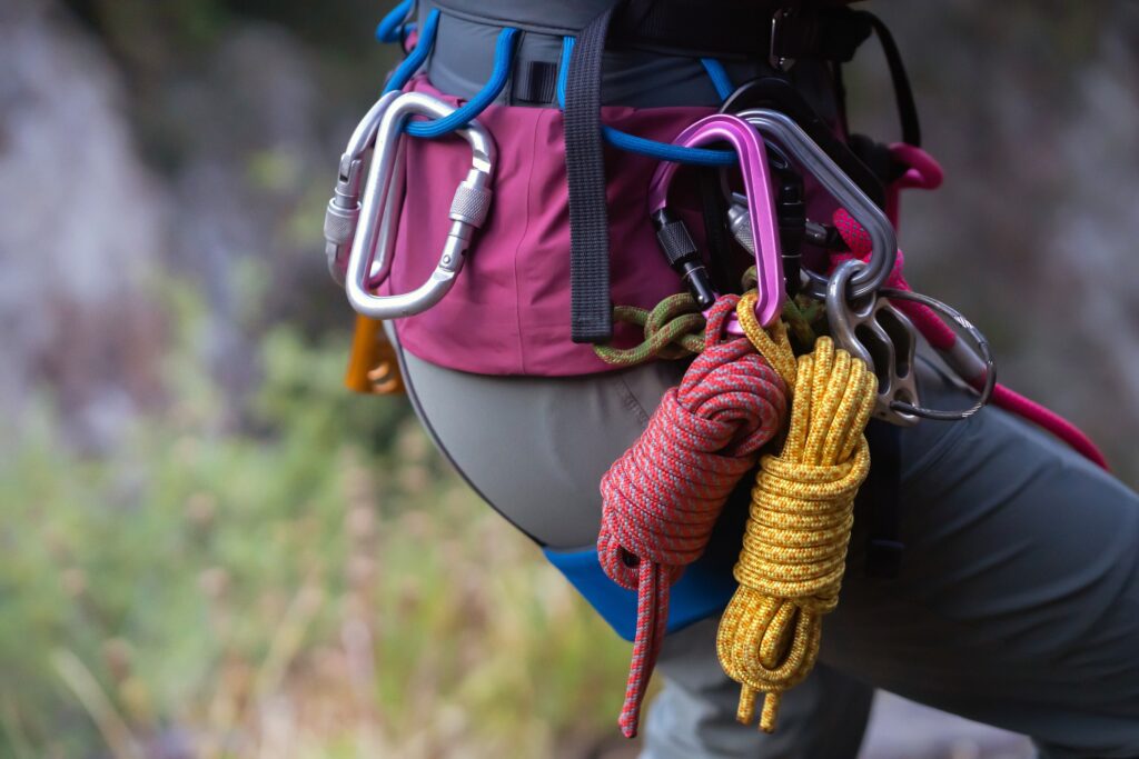 Close view of ropes, carabiners and rock climbing equipment around a woman's waist. 